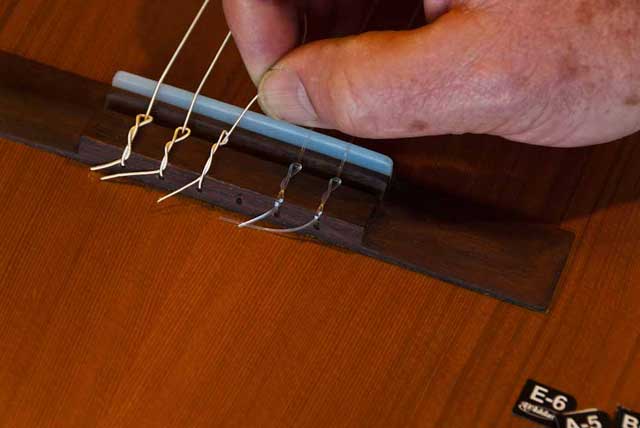 Placing the D string on the bridge of a classic guitar